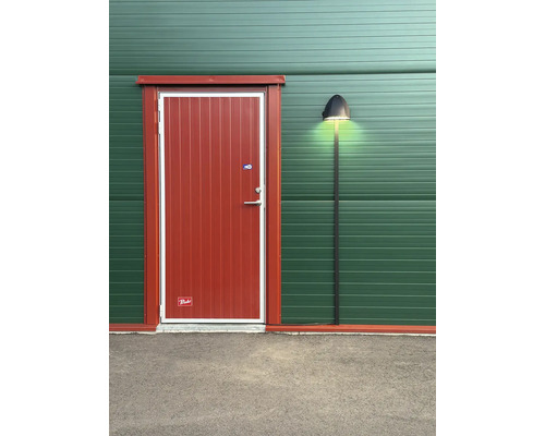 Exteriör av en byggnad med en dörr och en utomhuslampa