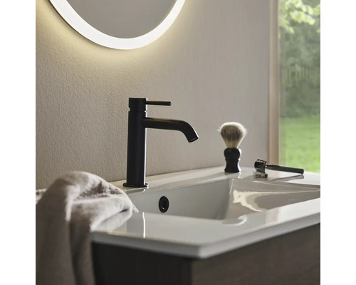 Tvättställ med svart armatur, rakborste och rakhyvel i badrummet