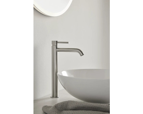 Tvättställsblandare i metall bredvid ett handfat