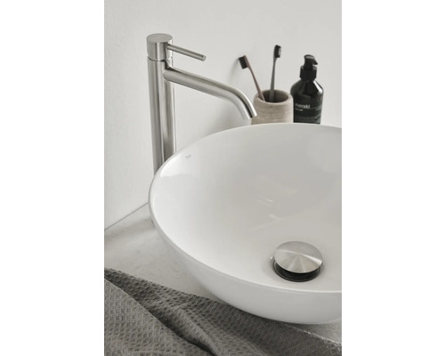 Bild av ett badrum med handfat, kran och handduk