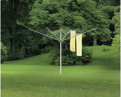 Roterande torkvinda med tvätt i trädgården