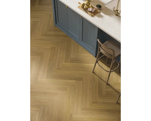 Läggning av träimitation klinker i fiskbensmönster i ett kök.