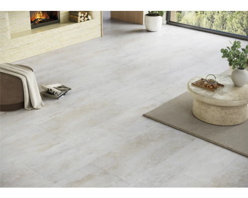 Ljust rum med lagt golv, öppen spis och sittmöbler