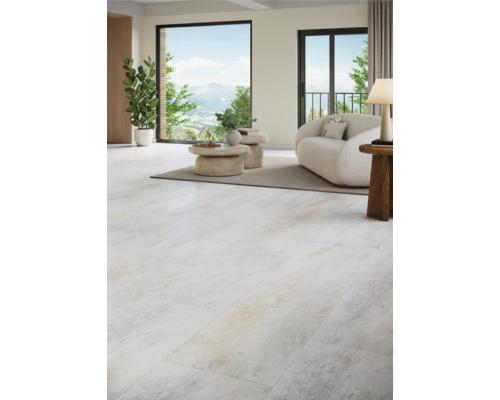 Ljust vardagsrum med klinkergolv i stenimitation, soffa och växter.