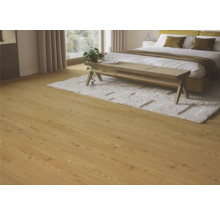 Ljust trägolv i ett sovrum med säng, matta och bänk