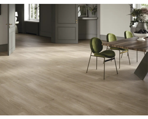 Ljust rum med trägolv, matbord och gröna stolar.