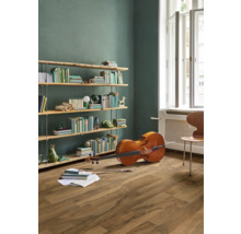 Vardagsrum med bokhylla, cello och trägolv