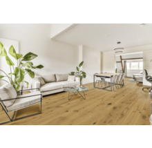 Vardagsrum med soffa, fåtölj, matbord och trägolv