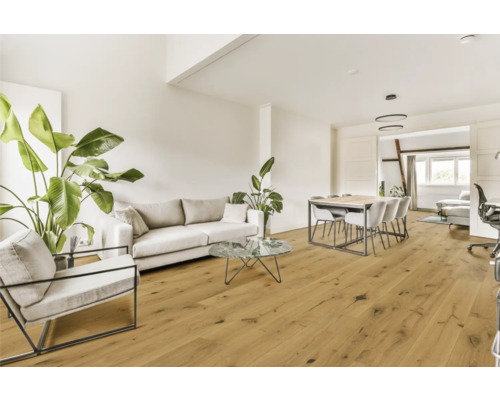 Vardagsrum med soffa, fåtölj, matbord och trägolv