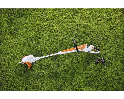 Batteridriven grästrimmer med två batterier på gräsmatta