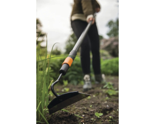 Trädgårdshacka med teleskopskaft som används i trädgården.