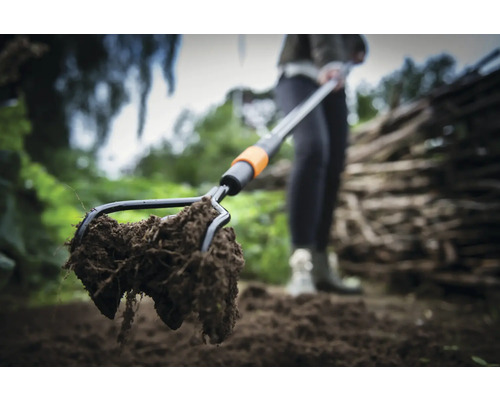 Närbild av en markgaffel med jord i trädgården.