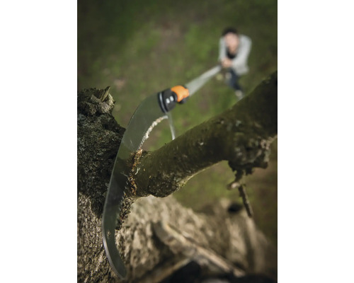 Grensax som skär av en trädgren i trädgården