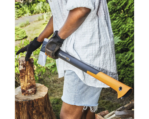 Person som hugger ved med en Fiskars X28 klyvyxa