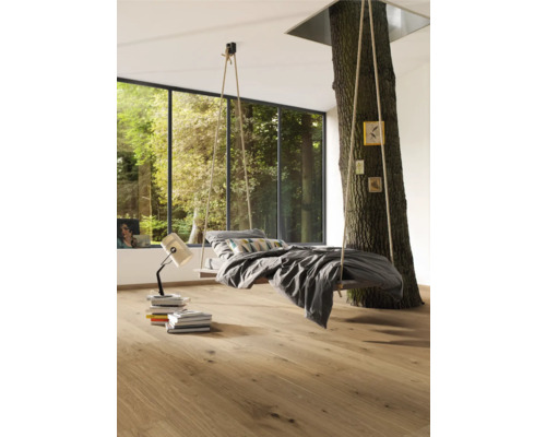 Ljust sovrum med hängande säng fäst vid ett träd och trägolv