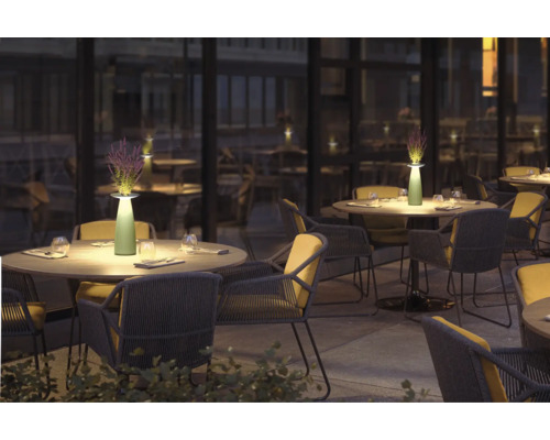 Utomhusområde med bord, stolar och bordslampor för en stämningsfull atmosfär