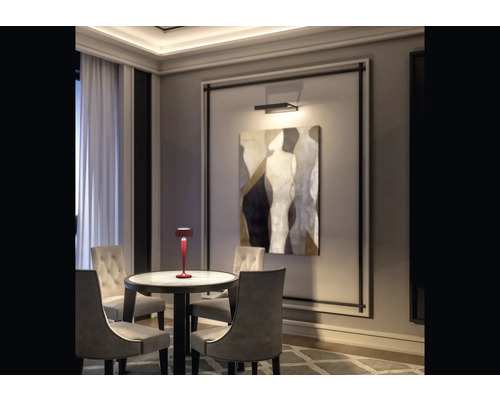 Scen med ett bord, stolar, en lampa och en målning
