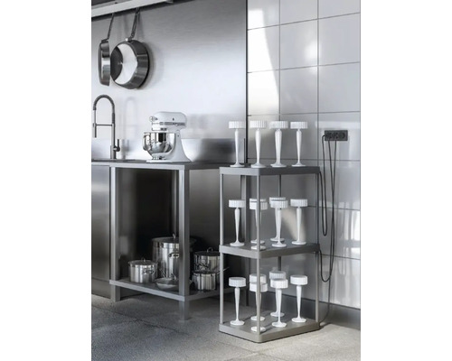 Köksscen med möbler i rostfritt stål, köksredskap och en golvlampa på en hylla