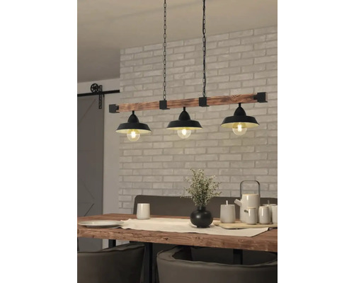 Pendellampa med tre lampor ovanför ett matbord i en matsal.