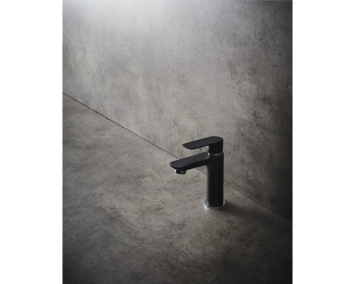 Svart tvättställsblandare framför en grå vägg