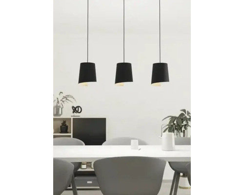 Tre svarta hänglampor över ett matbord i ett ljust rum.