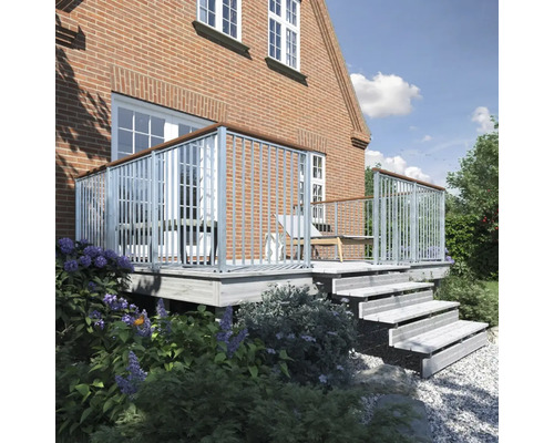 Terrass med trappa, räcke och planteringar framför ett tegelhus