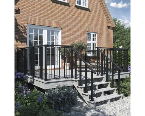 Terrass med metallräcke framför ett hus med en tegelvägg