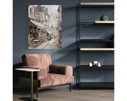 Vardagsrum med fåtölj, sidobord, hylla och målning av en gatuscen