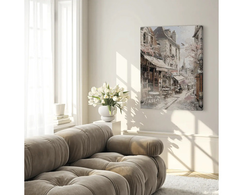 Vardagsrum med soffa och inramad målning av en gatuscen