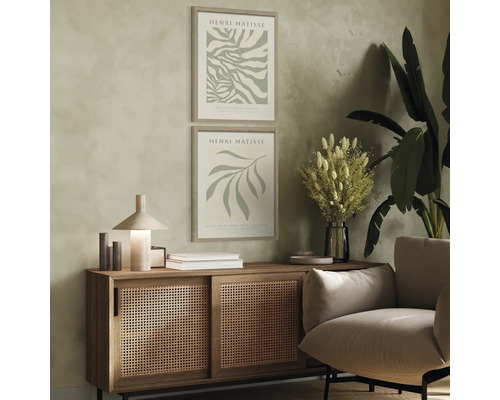 Vardagsrum med två inramade Henri Matisse-affischer, byrå, lampa och fåtölj