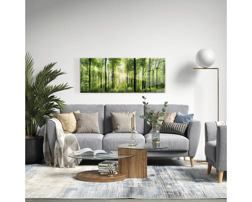 Vardagsrum med grå soffa, soffbord och väggmålning med skogsmotiv