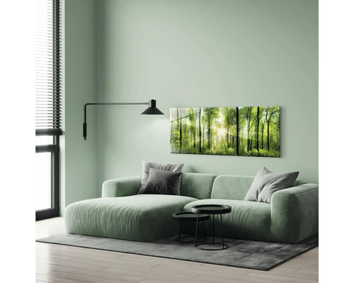 Vardagsrum med soffa, väggmålning med skogsmotiv och vägglampa