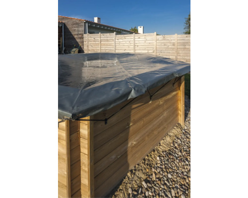 Träpool med grått poolskydd i trädgården