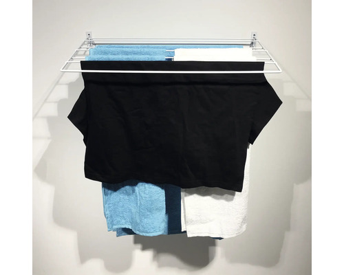 Väggmonterad torkställning med tvätt hängd på torkning.