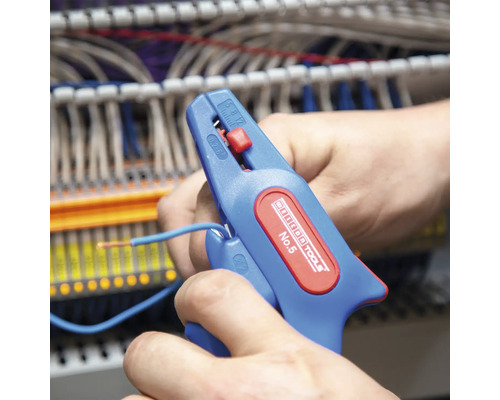 En person använder en automatisk avisolerare för att skala en blå kabel.