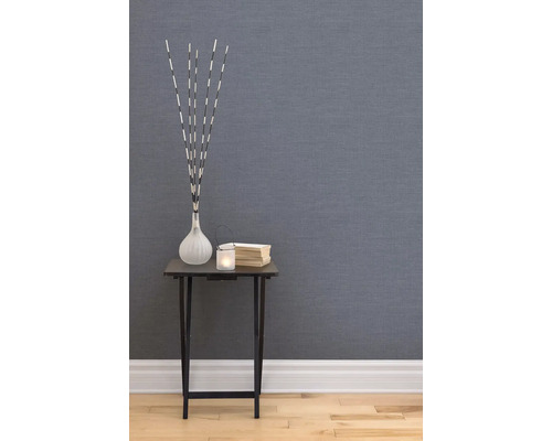 Dekorativt rum med glasfiberväv, litet bord med dekorationer som en vas, ett ljus och böcker.