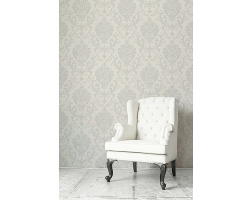 Klassisk fåtölj framför blommönstrad tapet för en elegant atmosfär