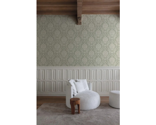 Inredningsidé med fåtölj, pall, sidobord i trä och mönstrad tapet