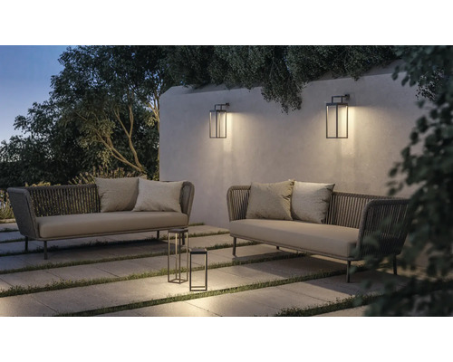 Uteplats med två soffor, bordslampa och vägglampor för trädgården