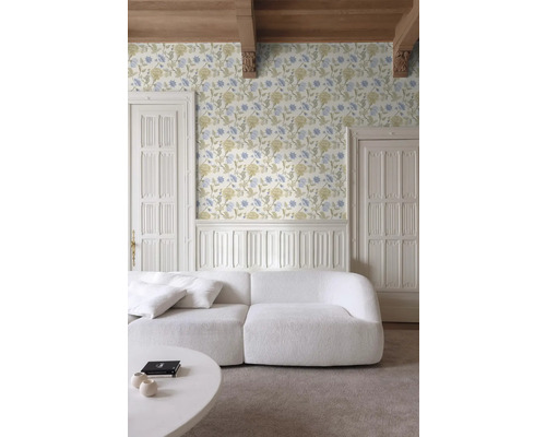 Vardagsrum med blommig tapet, vit soffa och takbjälkar i trä