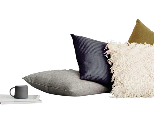 Dekorativ kuddarrangemang med kopp på bricka