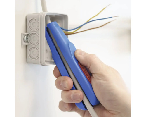 En hand använder en avisoleringstång på en elkabel i en kopplingsdosa