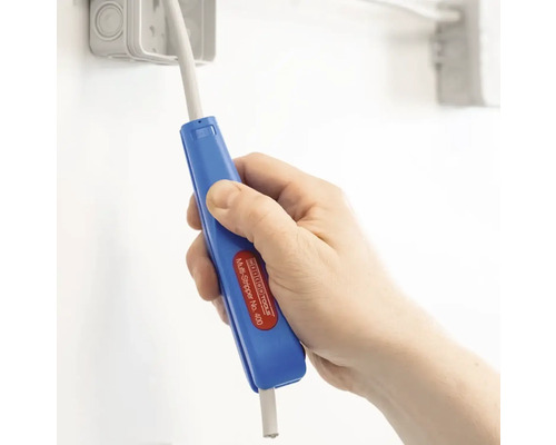 Hand håller en blå avisolerare för att ta bort isoleringen från en kabel