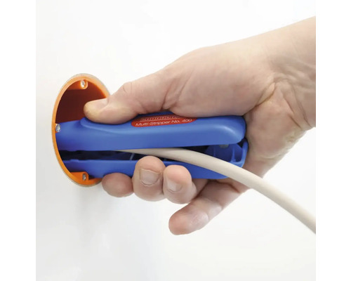 En hand använder en blå kabelskalare på en kabel i en kopplingsdosa.