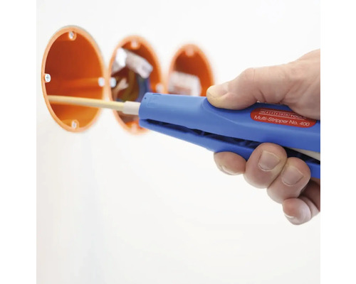 En person använder en avisoleringstång på en elektrisk ledning i en kopplingsdosa.