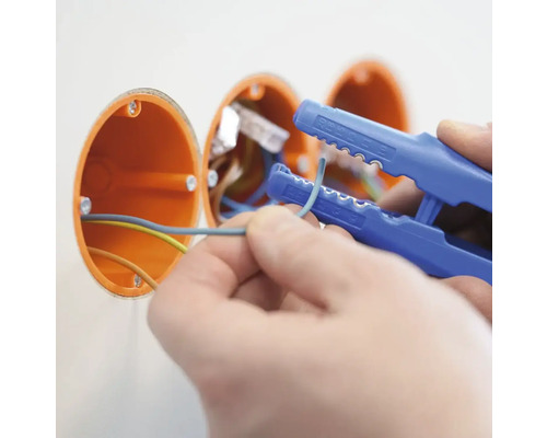 Elektriker som arbetar med en avisoleringstång på elkablar i en väggdosa.