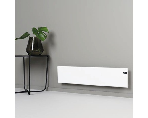 Platt, vitt element monterat på en grå vägg, bredvid ett sidobord med en växt.