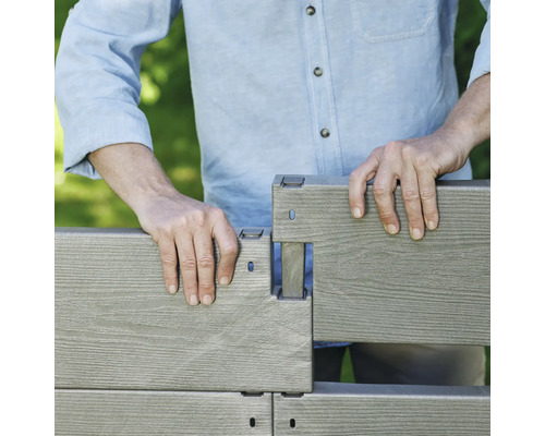 En person monterar ett kompositstaket.