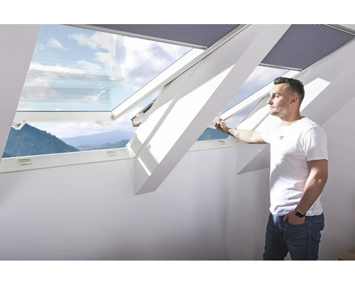 Man öppnar ett takfönster med utsikt utåt