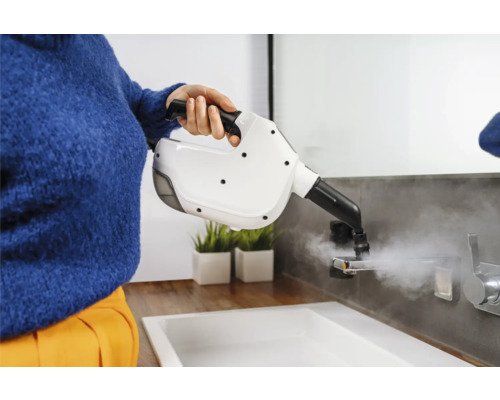 Kvinna rengör ett handfat med en ångtvätt